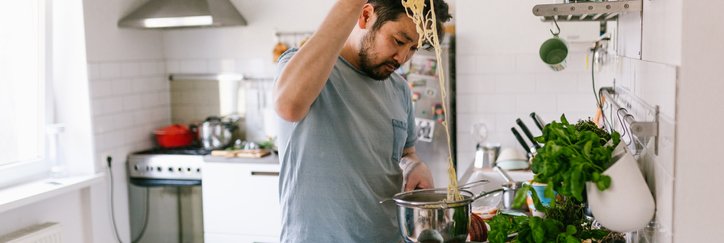 A man cooking pasta in his kitchen at home.