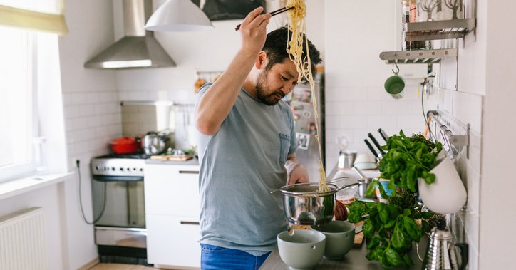 A man cooking pasta in his kitchen at home.
