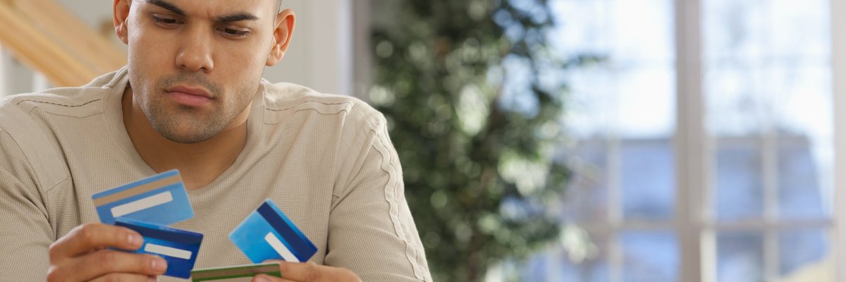 A man holding several credit cards.