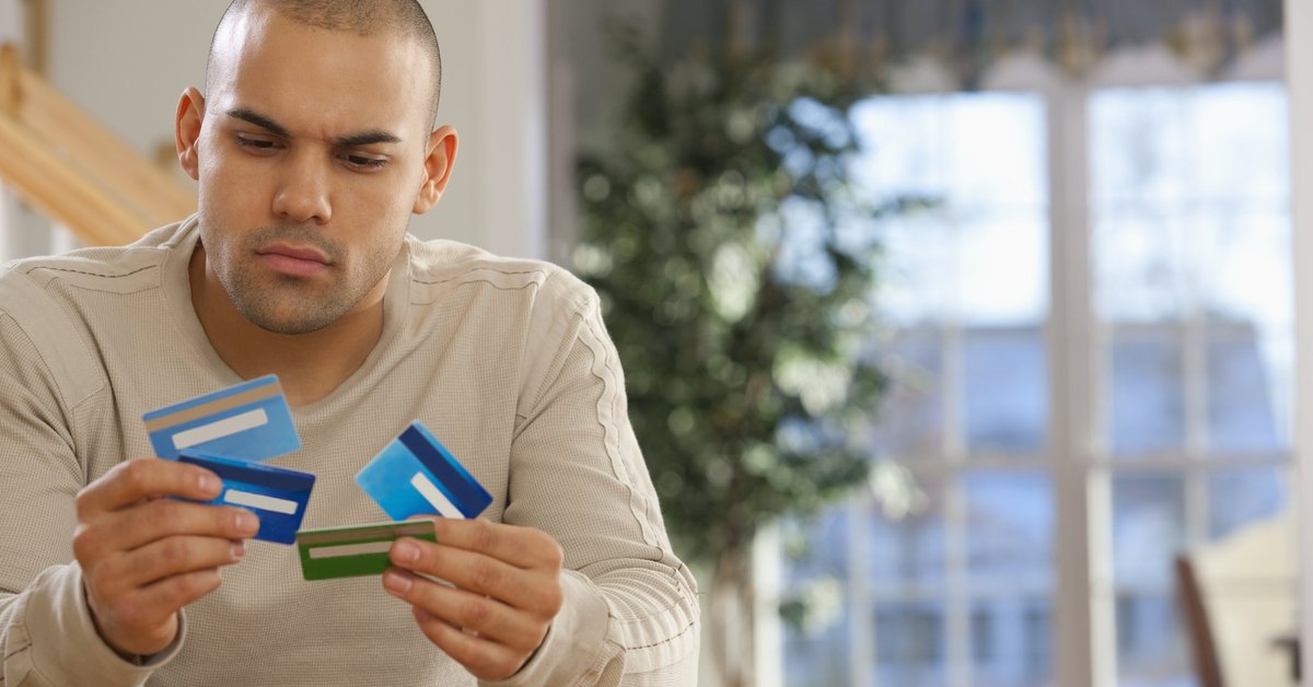 A man holding several credit cards.