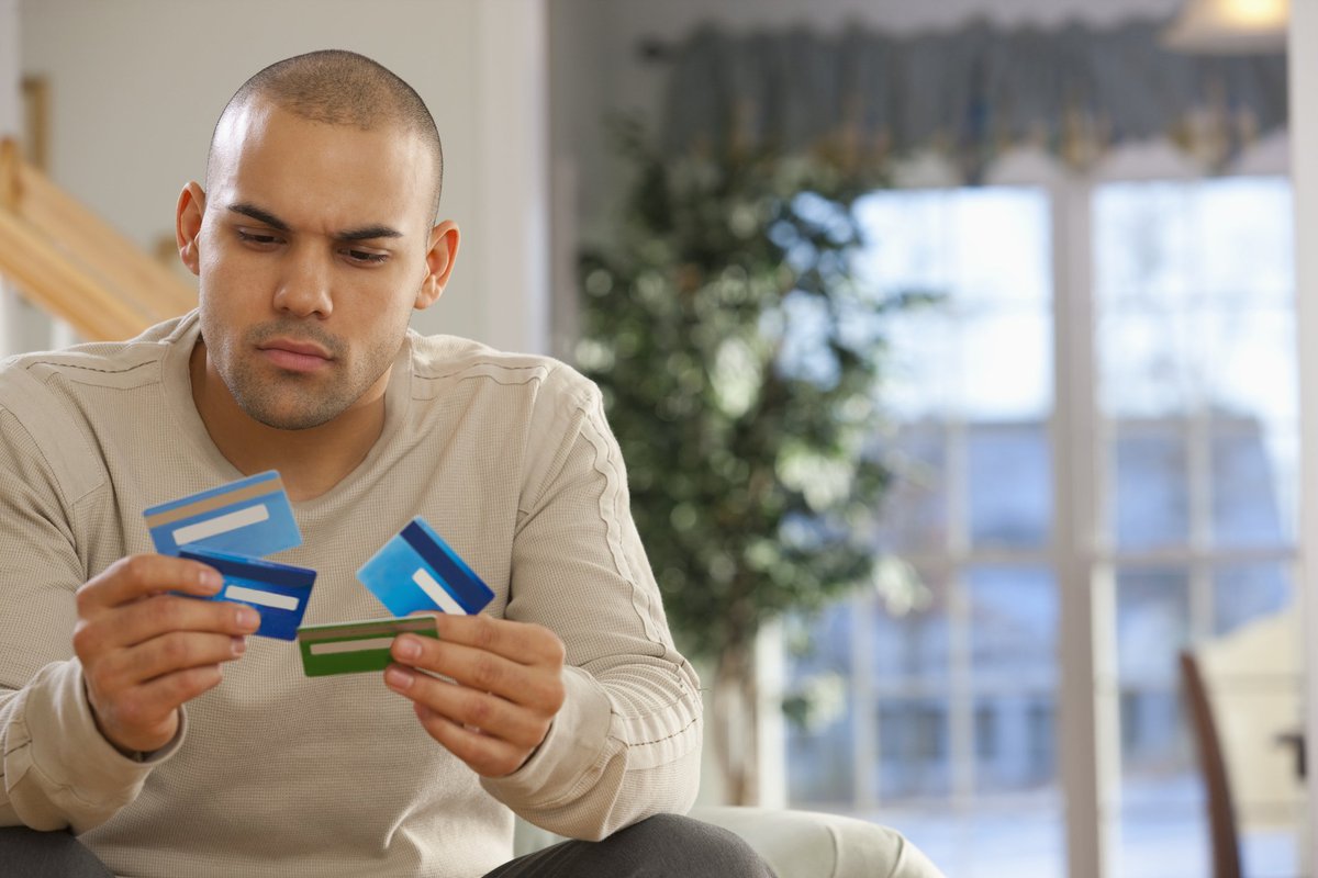 A man holding several credit cards.