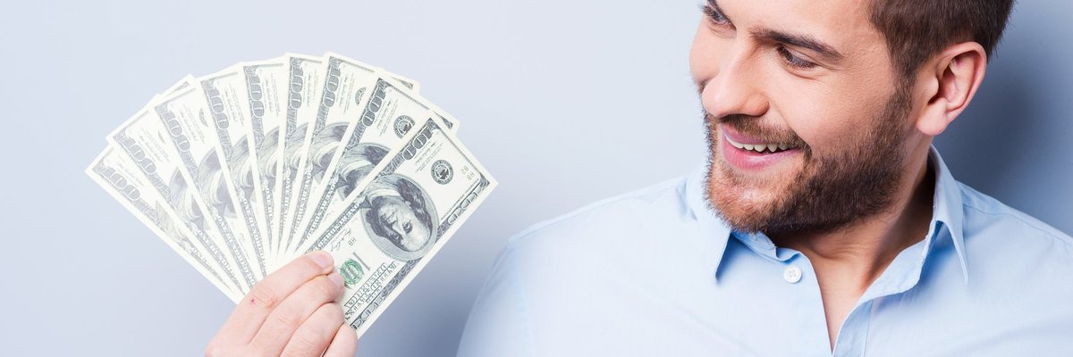Smiling man holding money in his hand.