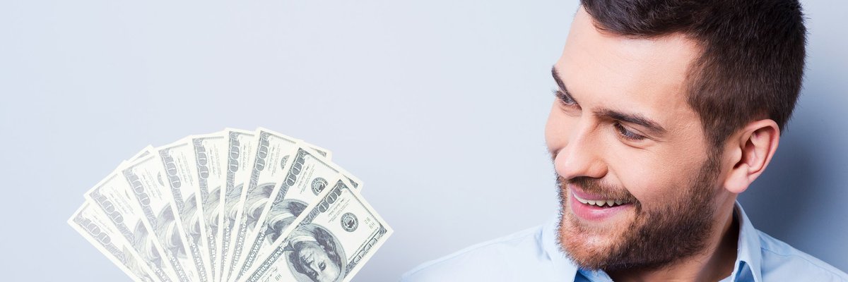 Smiling man holding money in his hand.