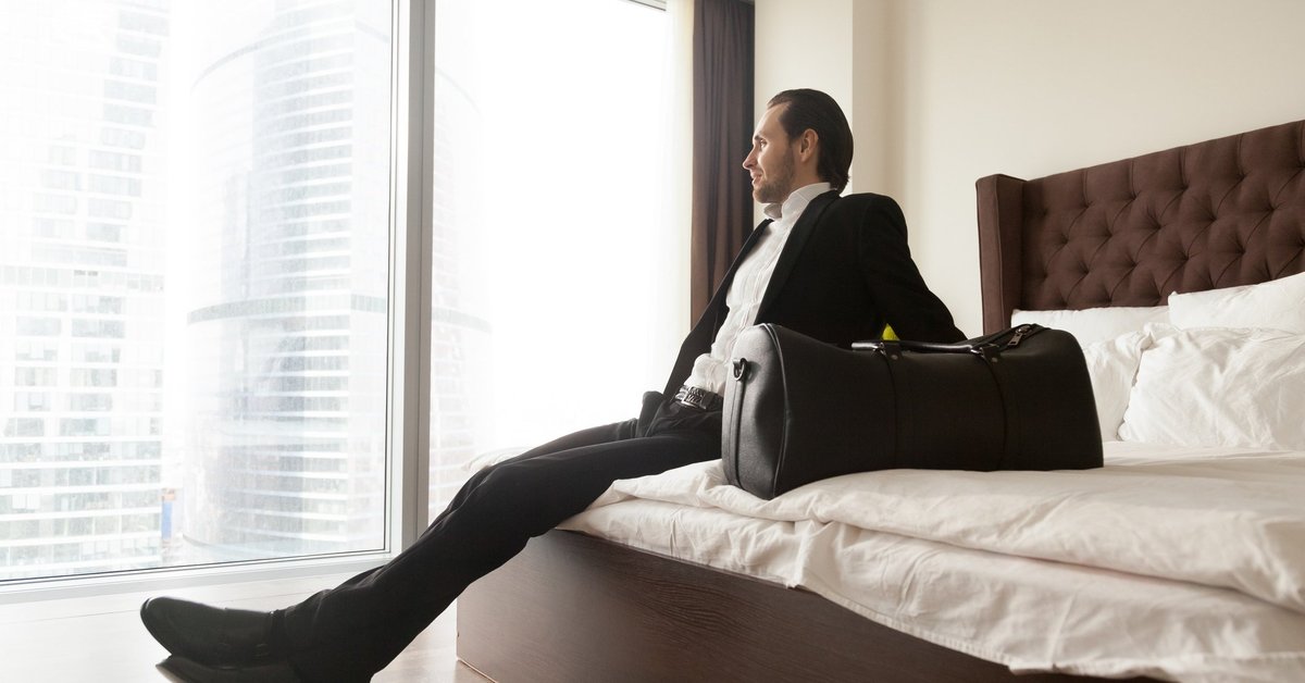 man in suit on hotel bed