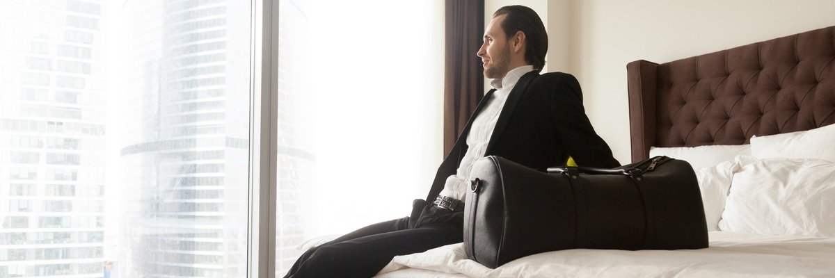 man in suit on hotel bed