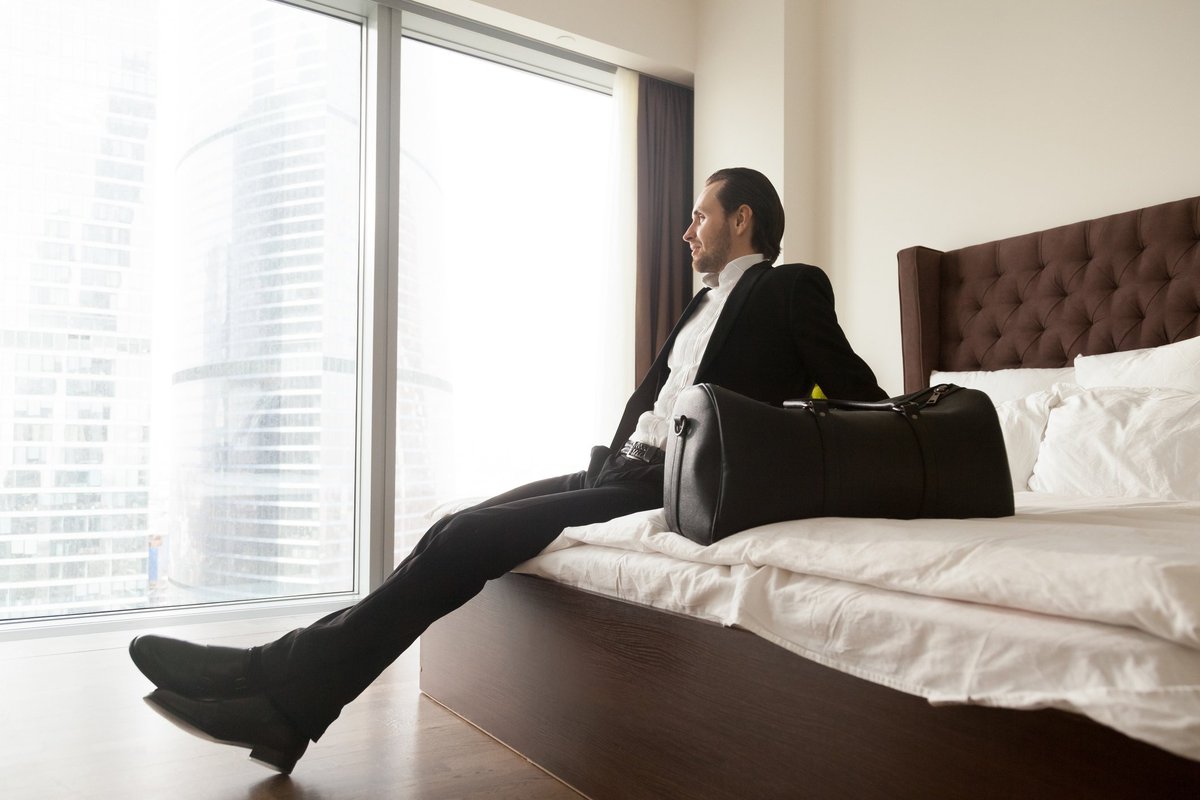 man in suit on hotel bed