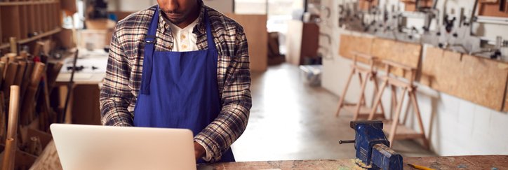 A man in a workshop using a laptop