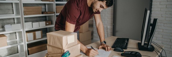 A small business owner in his back office preparing boxes for shipment.