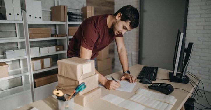 A small business owner in his back office preparing boxes for shipment.