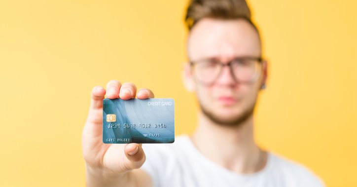 A man holds out a credit card