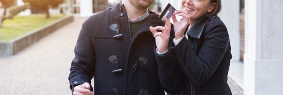 young couple shopping with both hands on a credit card