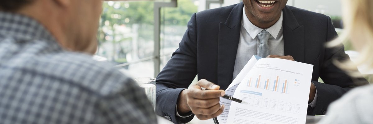 Couple talking with financial advisor and looking at paperwork. 