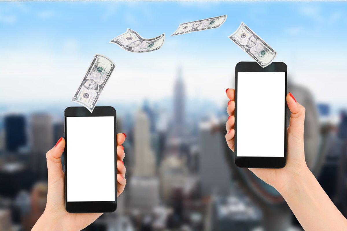 Five-dollar bills flying between two cell phones