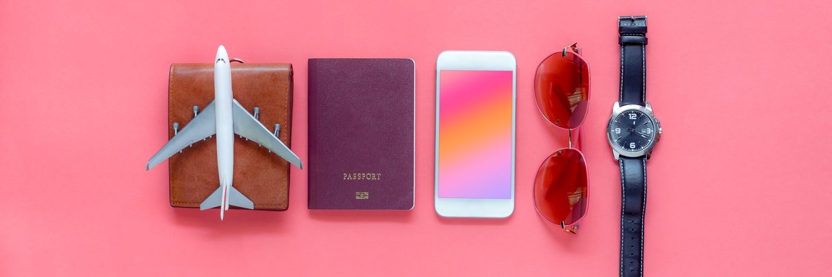 A wallet, toy airplane, passport, phone, sunglasses, and watch on a pink background.