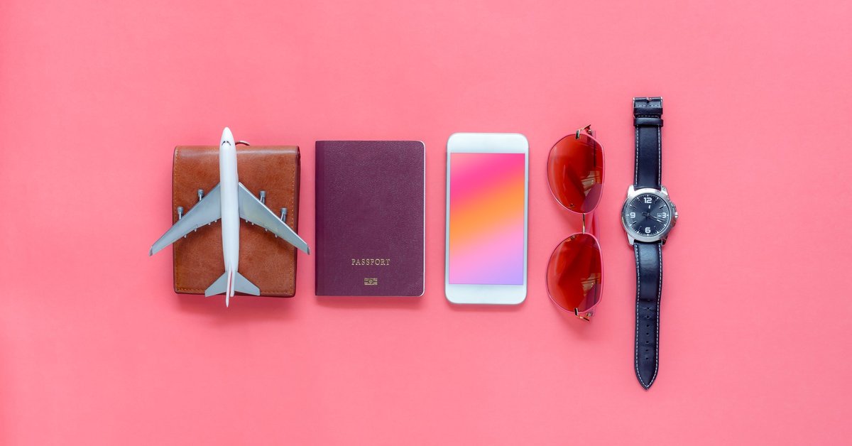A wallet, toy airplane, passport, phone, sunglasses, and watch on a pink background.