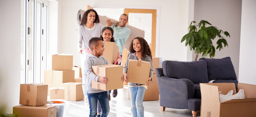 A family bringing moving boxes into a house