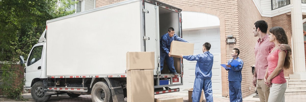  A couple moving into a home with a moving truck.