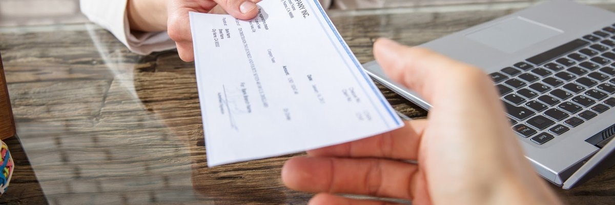 Woman handing over a check at a desk