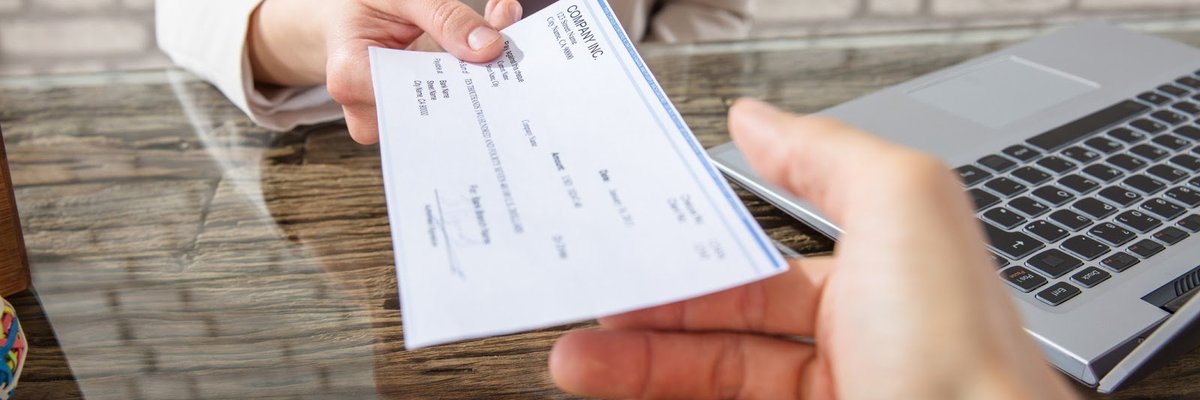 Woman handing over a check at a desk