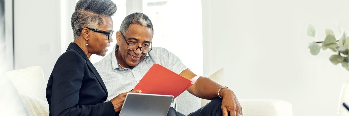 A financial advisor meets with an older man at his home.