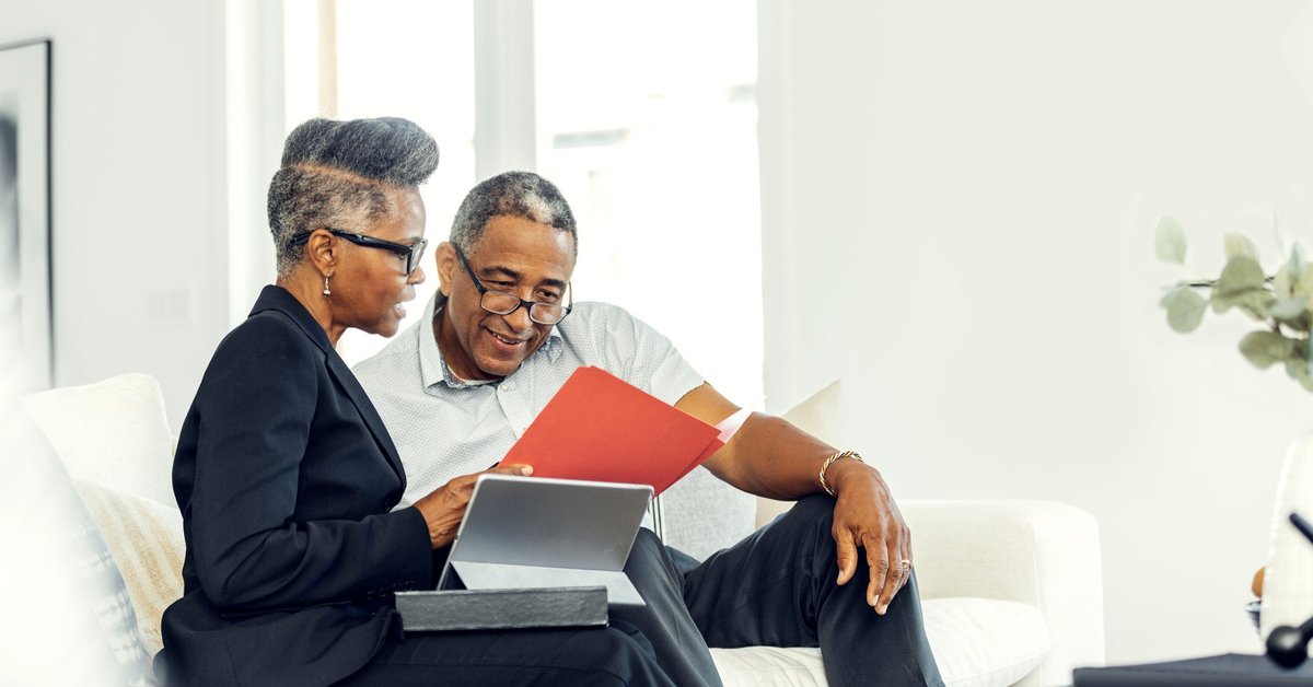 A financial advisor meets with an older man at his home.