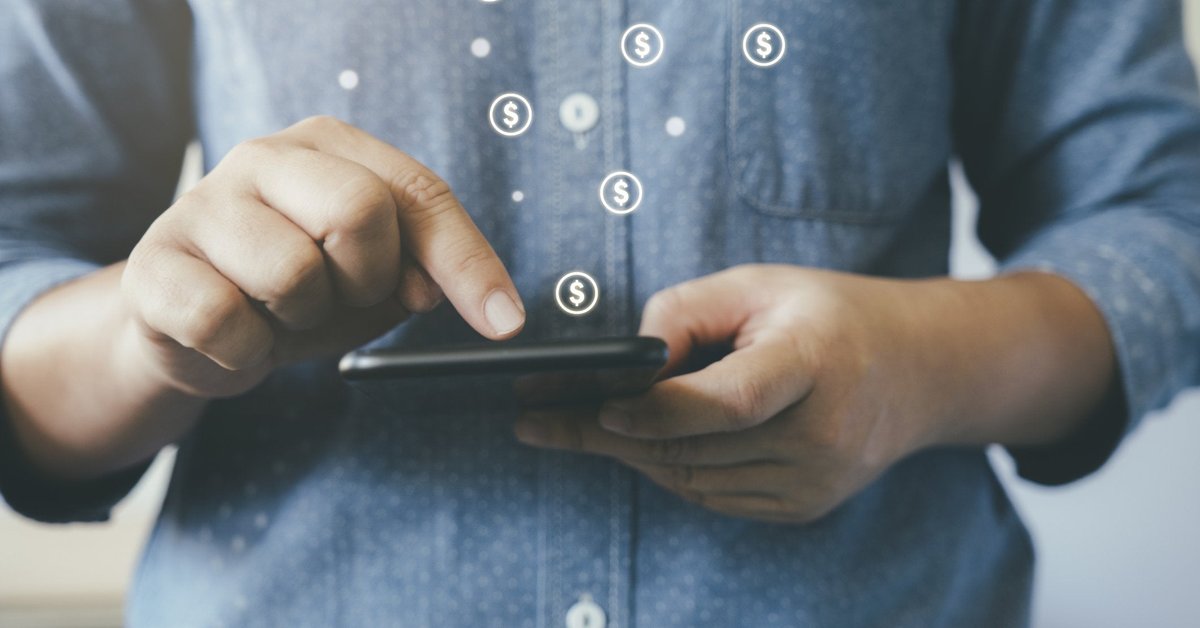 Man making online payment with dollar signs floating out of smartphone.