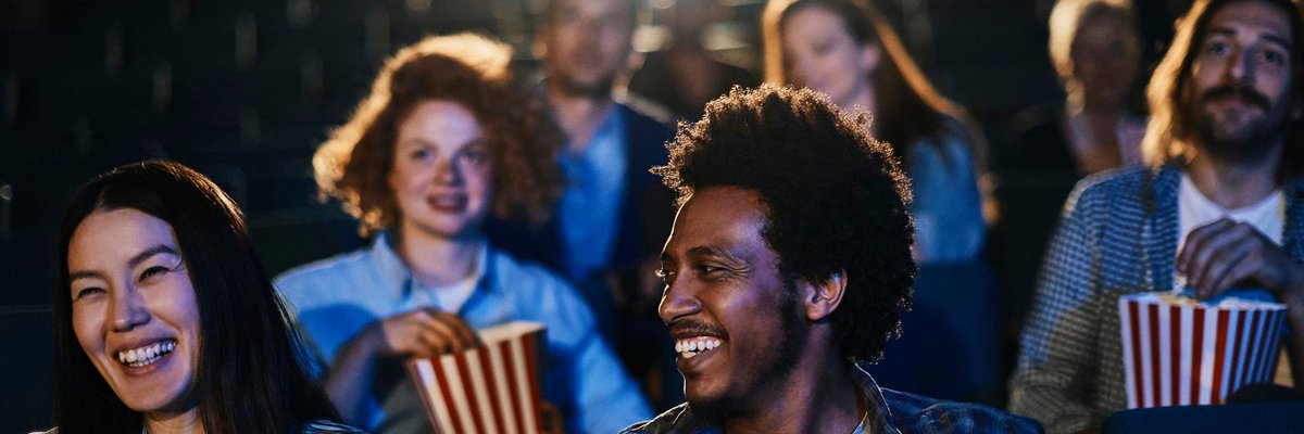 People eating popcorn while sitting in a movie theater.