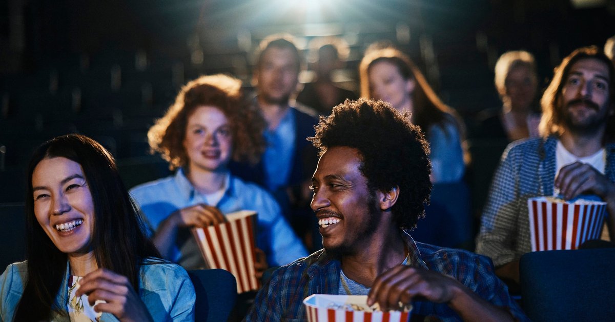 People eating popcorn while sitting in a movie theater.