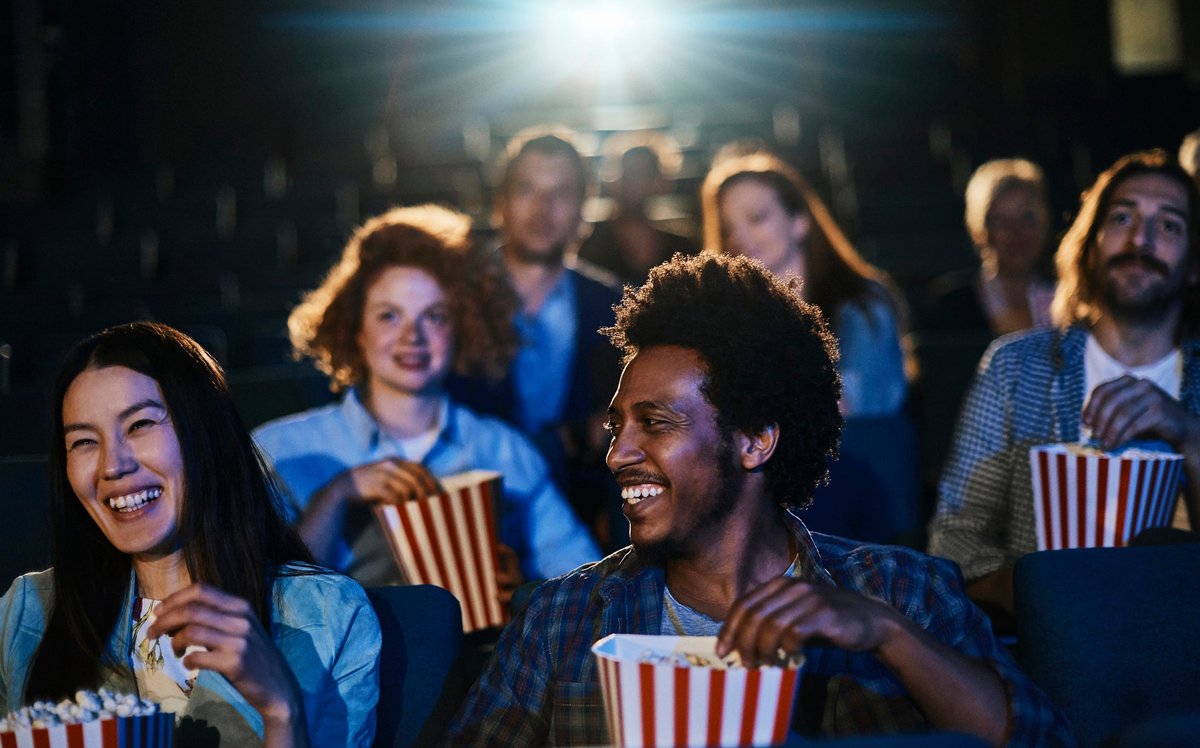 Leute Essen Popcorn, Während Sie In Einem Kino Sitzen.