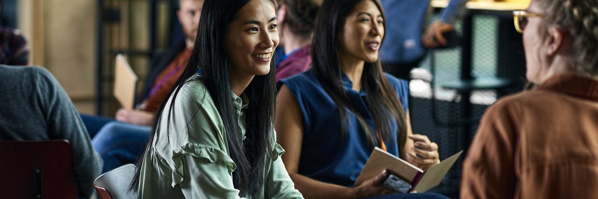 Smiling people sitting and talking during a convention.