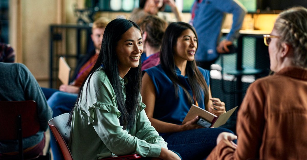 Smiling people sitting and talking during a convention.