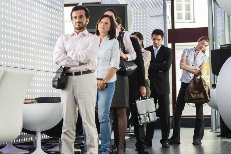 A group of people waiting in line at a bank.