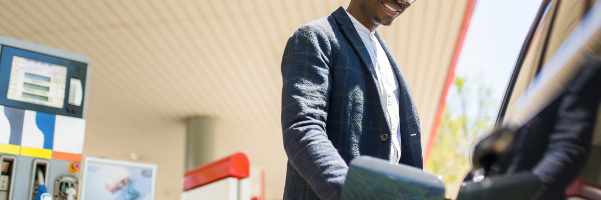 A person filling up their car at the gas station.