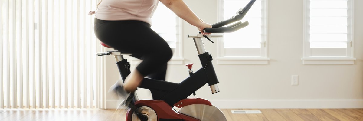 A person on an exercise bike in their living room at home.