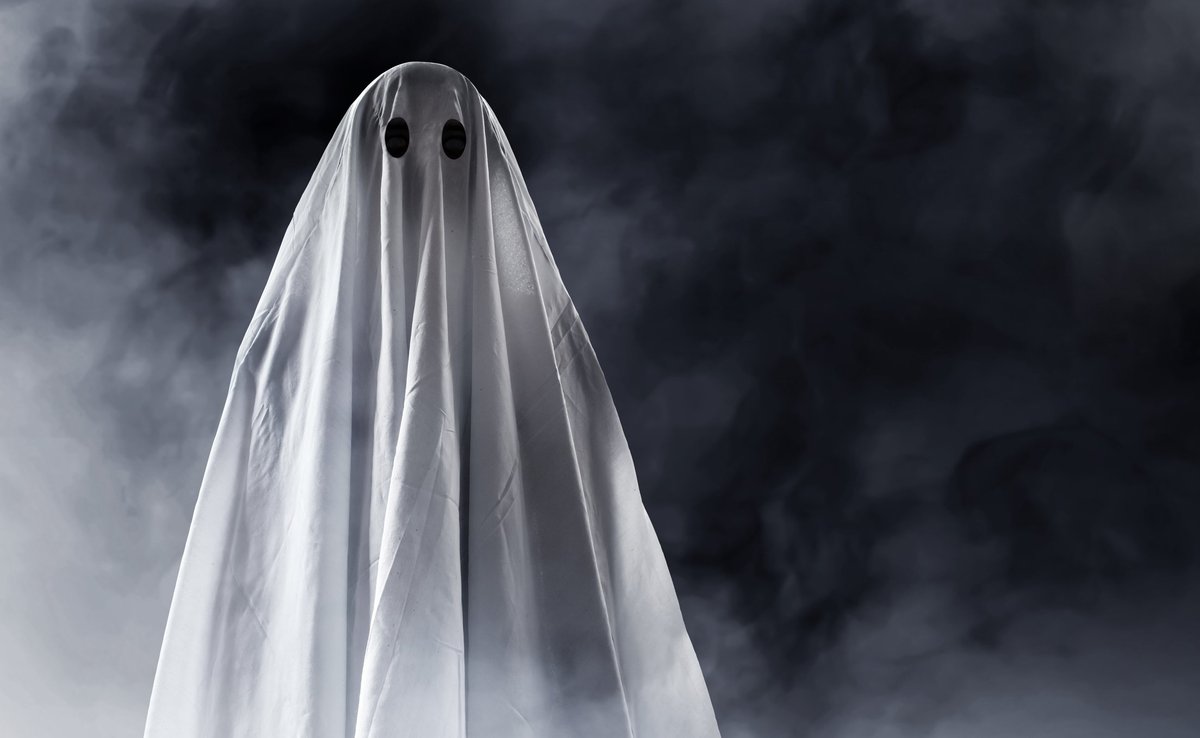 person wearing a sheet as a ghost costume for Halloween.