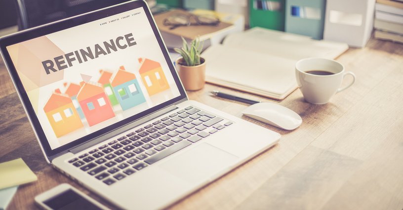 A laptop with the word "refinance" on the screen
