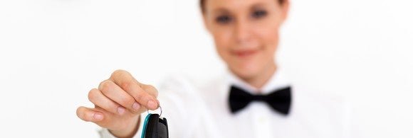 car rental company employee handing over car key to client