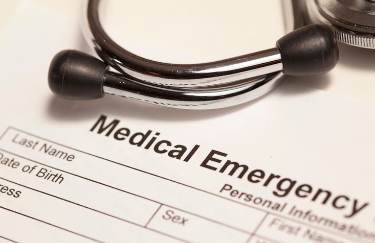 A stethoscope on top of a medical emergency form.