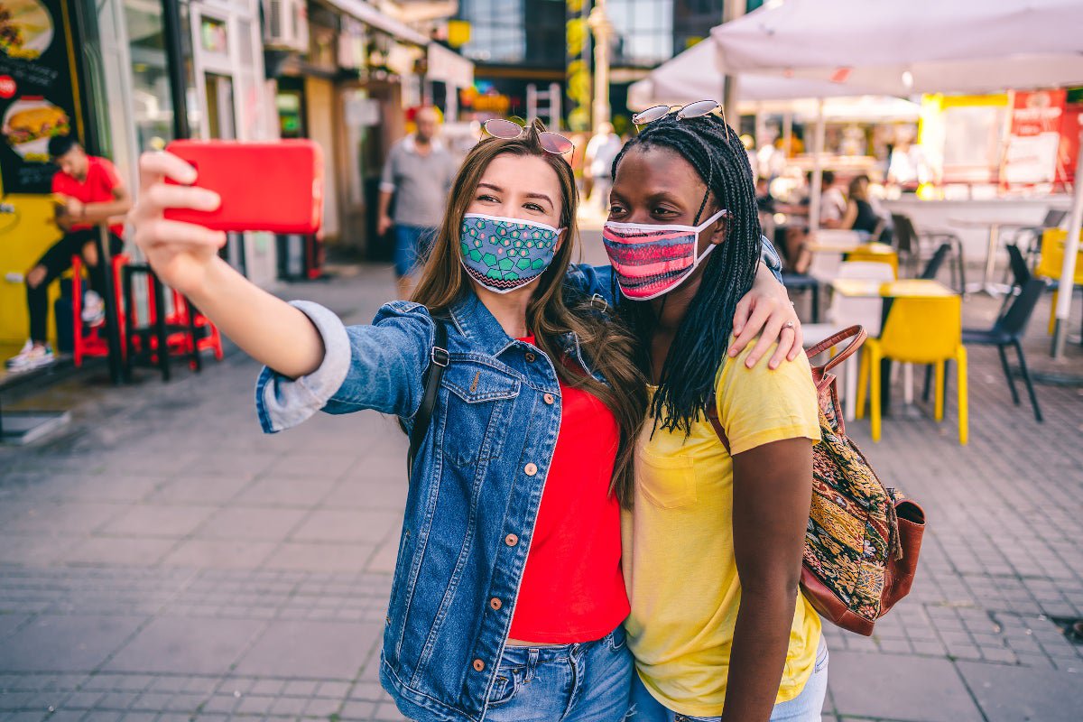 A pair of women taking a selfie together on a city street.