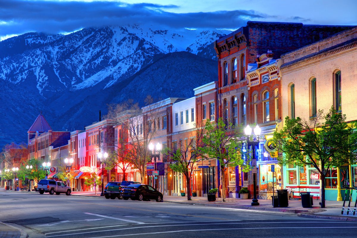 A shopping street in Ogden, Utah, at dusk, in front of a snowcapped mountain.