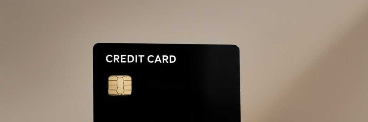 A plain black credit card sits on a marble ledge.