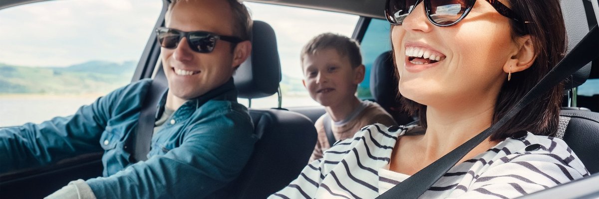 Family on a road trip with shades on and windows down.