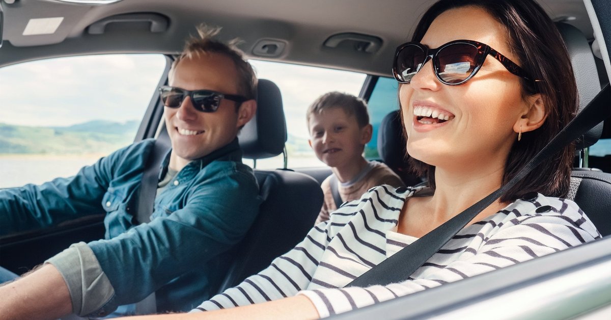 Family on a road trip with shades on and windows down.