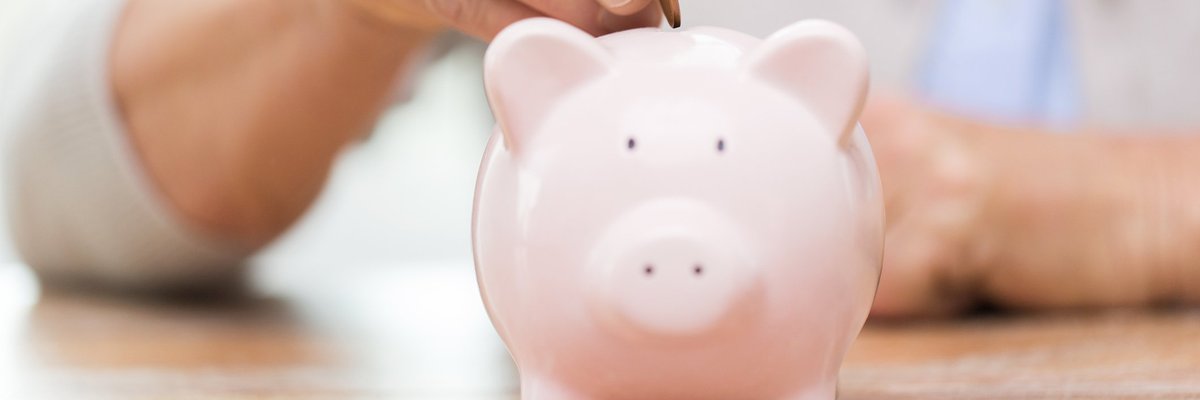 Woman dropping coin into piggy bank