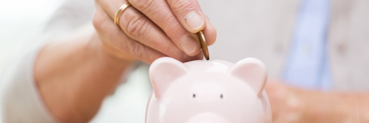 hand inserting quarter into piggy bank