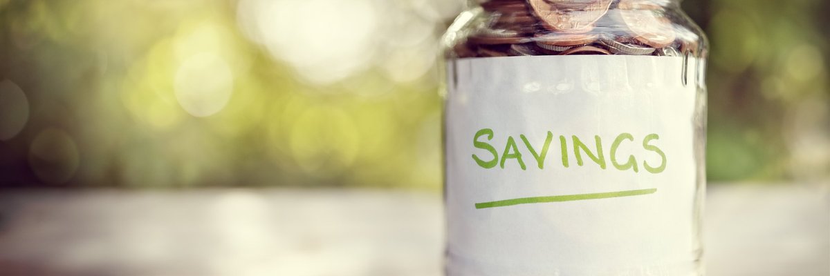 Jar filled with coins and labeled Savings.