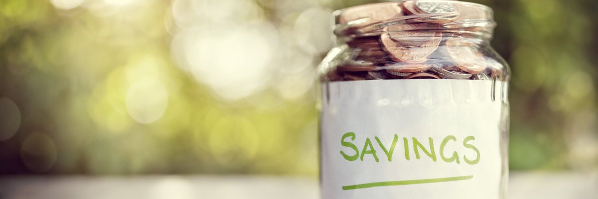 Jar filled with coins and labeled Savings.