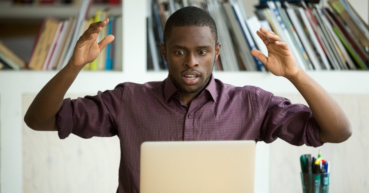 Shocked man looking at laptop