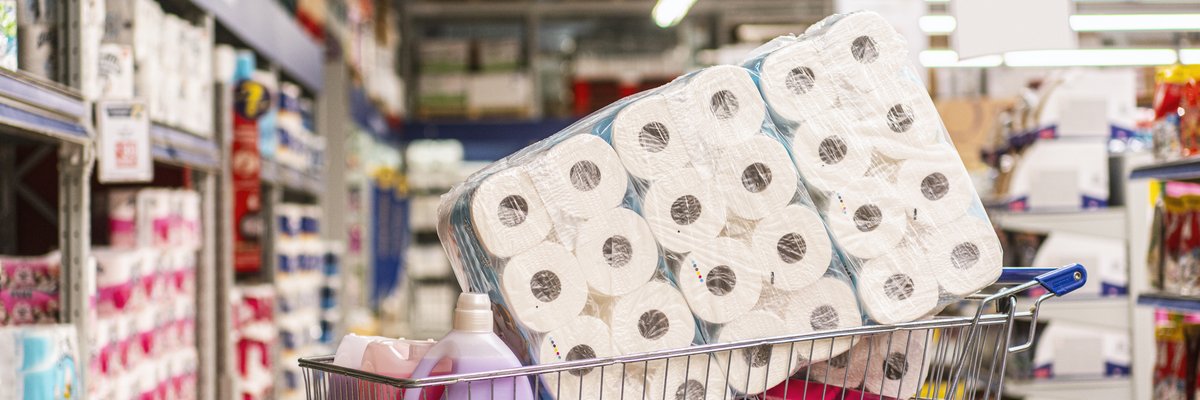 A shopping cart full of cleaning products in a big-box store.