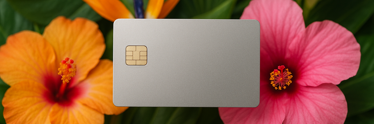 Silver credit card with tropical flowers in background.